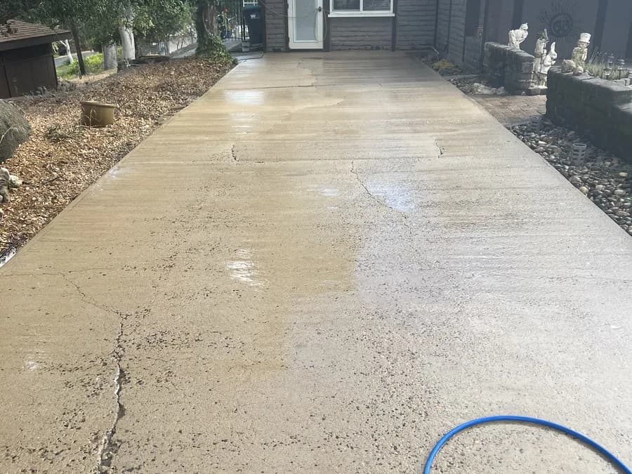 The same residential driveway after pressure washing, showing clean concrete