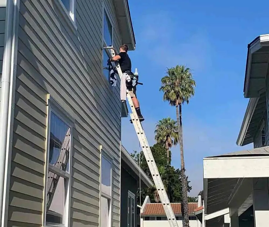 Crystal Clean A1 working from a ladder on a two story property in San Luis Obispo County
