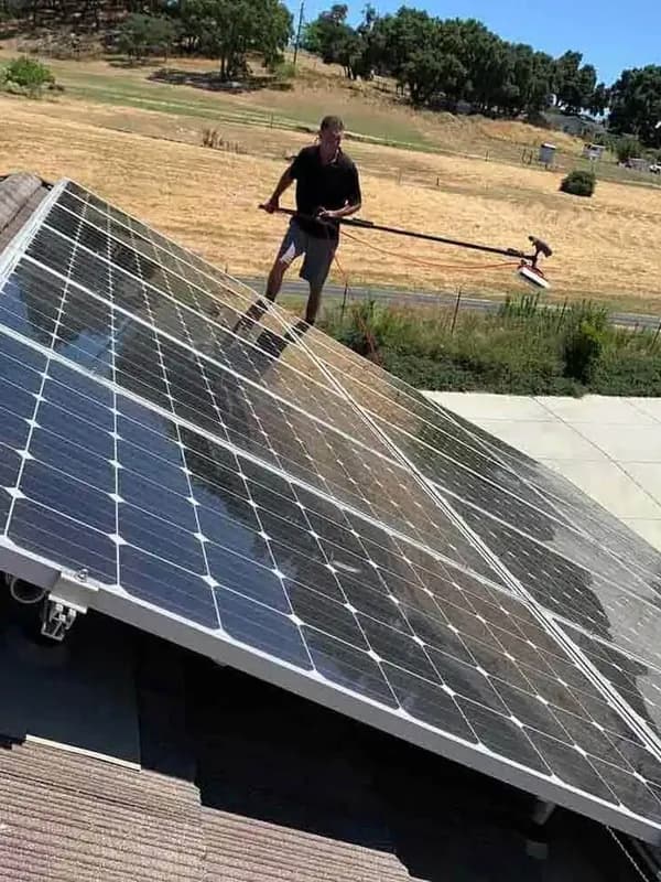 Cleaning a ground mounted solar array with a brush pole